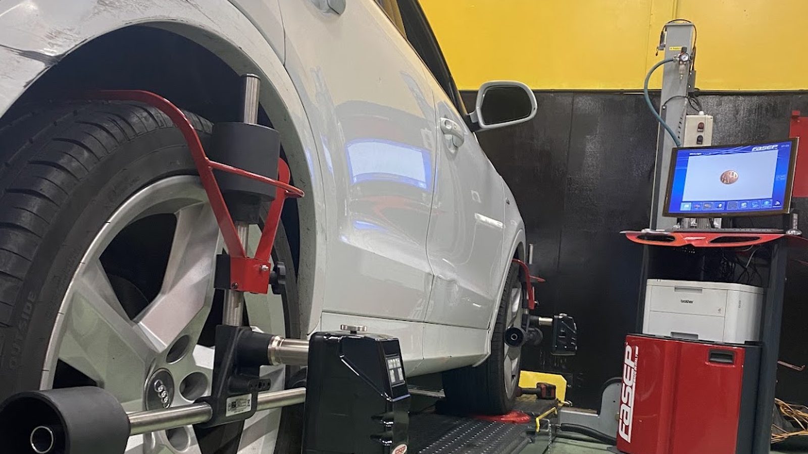 A wheel alignment machine at work on a car in a South End Motors workshop